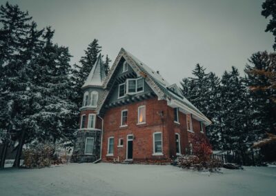 snowy scene with the drummond manor lit up with christmas lights in time for the holidays